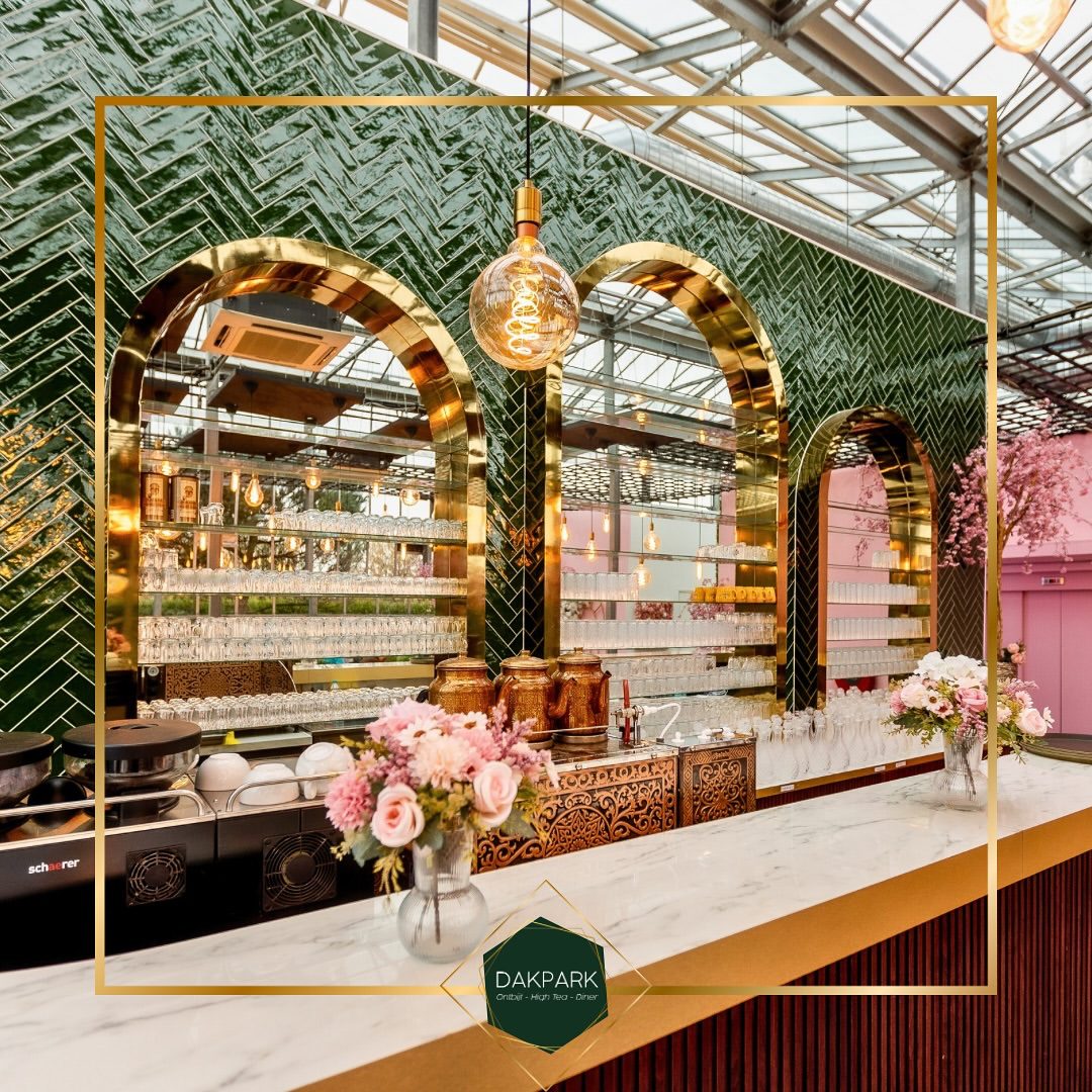 De bar met groene tegels, gouden bogen en verse bloemen