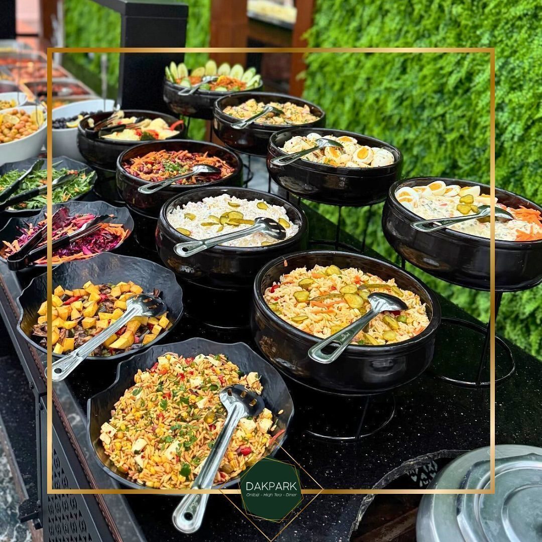 Warm buffet in zwarte pannen voor een groene wand