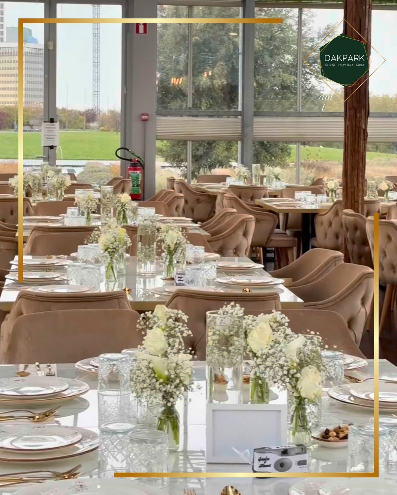 Lange feesttafel met witte bloemen en goud bestek
